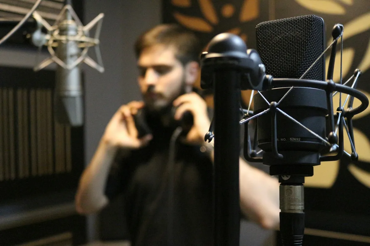 A musician singing into a studio microphone