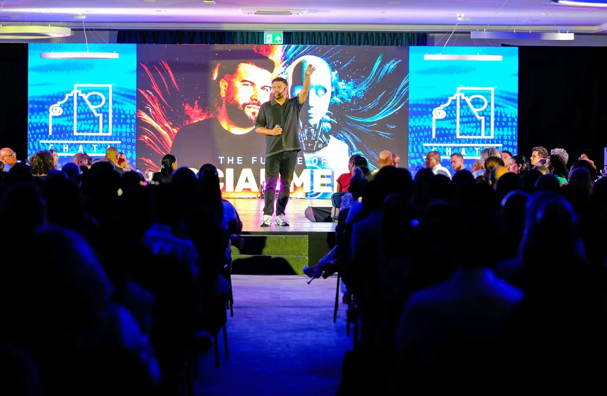 A speaker on stage in front of a large audience